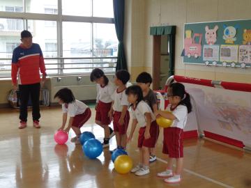 室内で幼児がボールを蹴る用意をしている様子