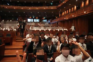 オーケストラの会場で熱心に聞き入っています。