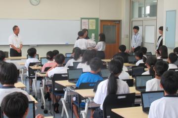 代表児童が三角巾を受け取っている様子