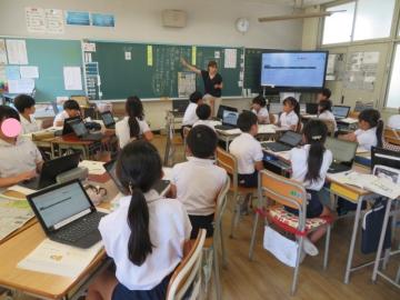 教室内で新聞記事について話し合う4年生の様子