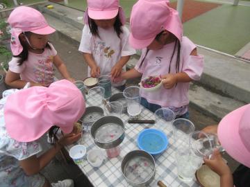 屋外で4歳児が色水遊びをしているところ