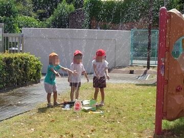 スプリンクラーで水遊びをしている写真