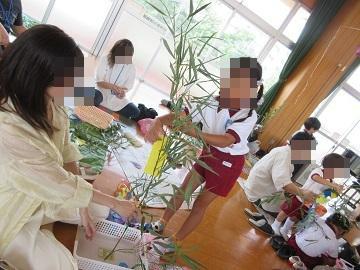 親子で笹飾りをしている写真