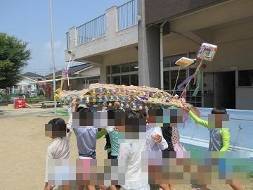 ペットボトルの船をプールに運んでいる写真