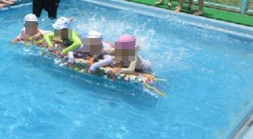 プールでペットボトルにつかまって泳いでいる写真
