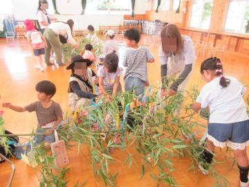 笹に飾りをつける親子