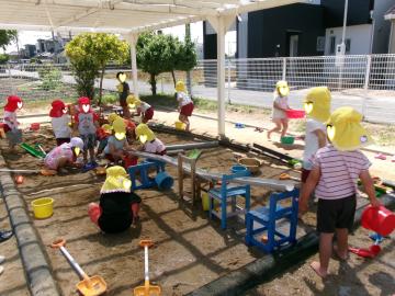 3歳児と4歳児が砂場で泥遊びをしているところ