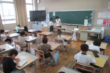 1年生の児童ひとり一人に通知表を渡している様子