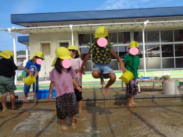 4歳児が泥遊びでジャンプをしているところ