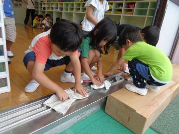 4歳児がドアの溝を掃除しているところ