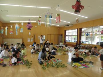 幼児が笹飾りを保護者と一緒につくっているところ