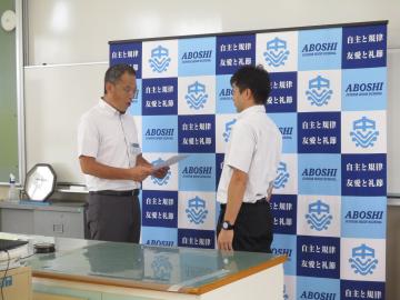 室内で市民大会一般男子の部で表彰を受ける先生の様子