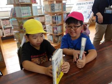 幼児が分厚い本を読んでみようとする姿