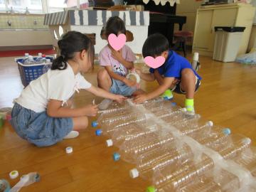 子供たちがペットボトルのボートを作っているところ