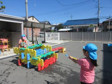 ペットボトルの的に向かって水鉄砲をしているところ