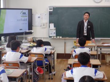 教室内で講師から金融の話を聞いている児童たちの様子