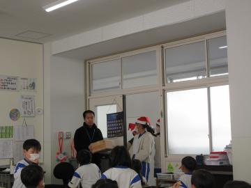 児童がサンタになってケーキを届けている様子