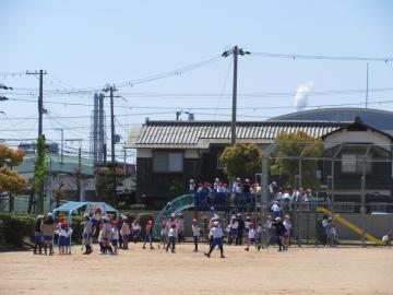 1年生と6年生が運動場で遊んでいる様子