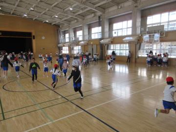 新1年生と6年生が体育館で遊んでいる様子