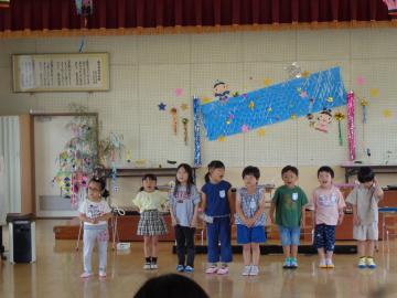 幼児がお客様の前で歌を歌っているところ