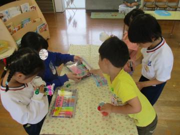 一緒に遊び、園児にペンをとってくれる中学生