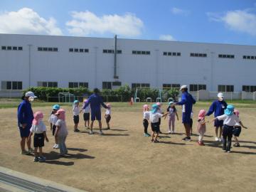 輪になって体操をする中学生と園児