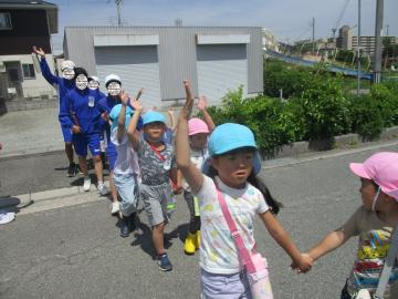 手を挙げて道路を横断する子供たち
