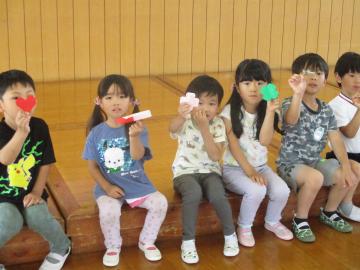 中学生が折った折り紙を嬉しそうに見せる子供たち(2)