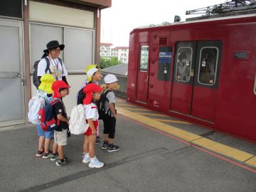 園児が駅のホームで電車に乗ろうとする様子