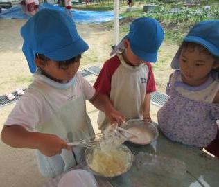 屋外で5歳児たちが泡クリームを作っている様子