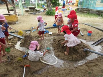 砂場の砂で島を作っている園児の様子