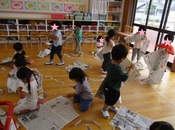 3歳児が新聞を破いて遊んでいる