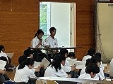会場内でマイクを持ちアナウンスする司会の生徒の様子