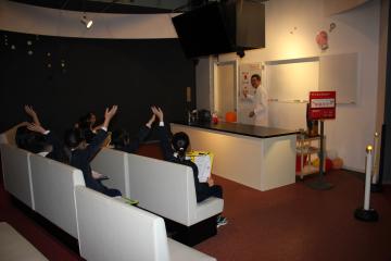 科学館内でサイエンスショーを見学する児童たちの様子