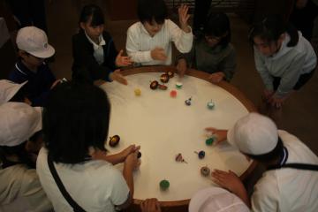 工芸館内でコマあそびをする児童たちの様子