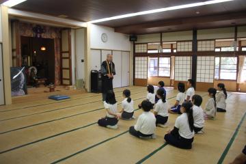 圓教寺で住職から講話を聴く児童たちの様子