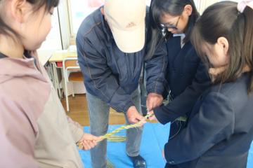 教室で3人ひと組で縄をなう児童たちの様子