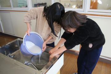 調理室でもち米を洗い、水を代えている児童たちの様子