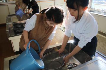 調理室でもち米を水で洗う児童たちの様子