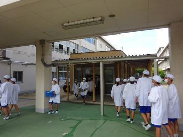校舎内で給食を運んでいる生徒たちの様子