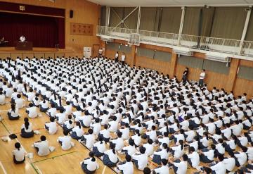 体育館で校長先生のお話を聞いている生徒たちの様子