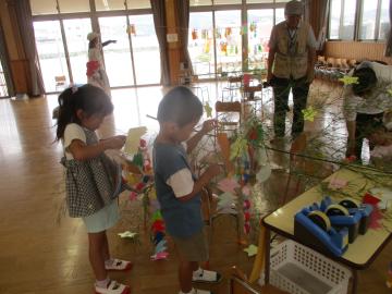 室内で笹飾りをつける園児の様子