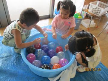 室内で縁日のヨーヨーすくいをする園児たちの様子