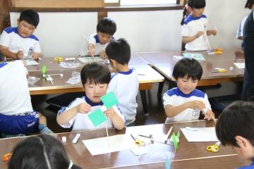室内でハサミ製作をする5歳児の様子