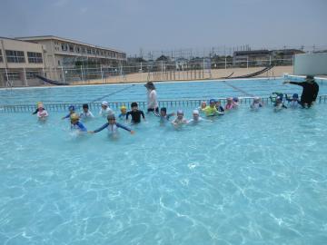 小学校のプールで遊ぶ子供たちの様子
