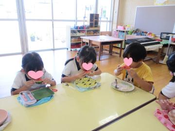 室内でスイカをみんなで食べている様子