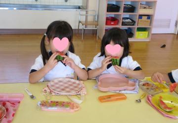 室内で園児がスイカを食べている様子