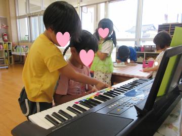 遊戯室内で園児がキーボードを演奏している様子