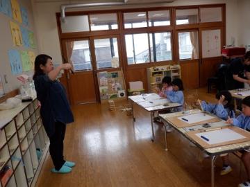 筆の持ち方を教えてもらっているところ