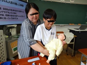 赤ちゃん人形を抱っこしている様子です。